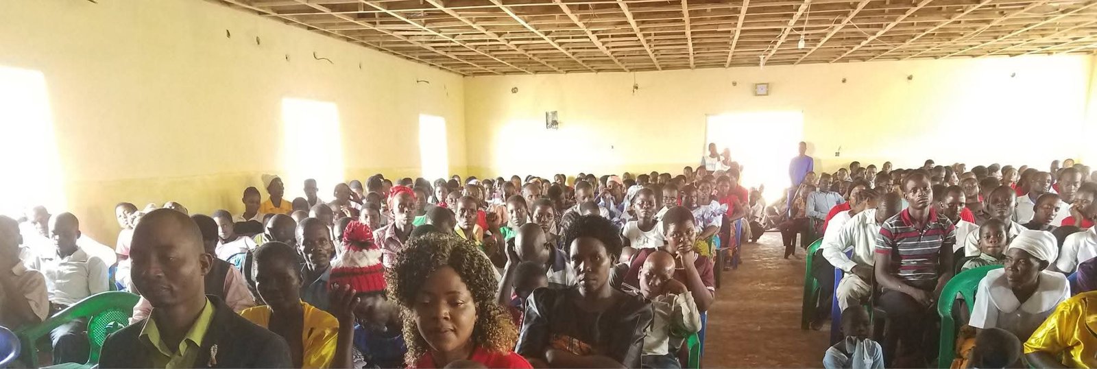 A wide view across a congregation gathered inside a hall.