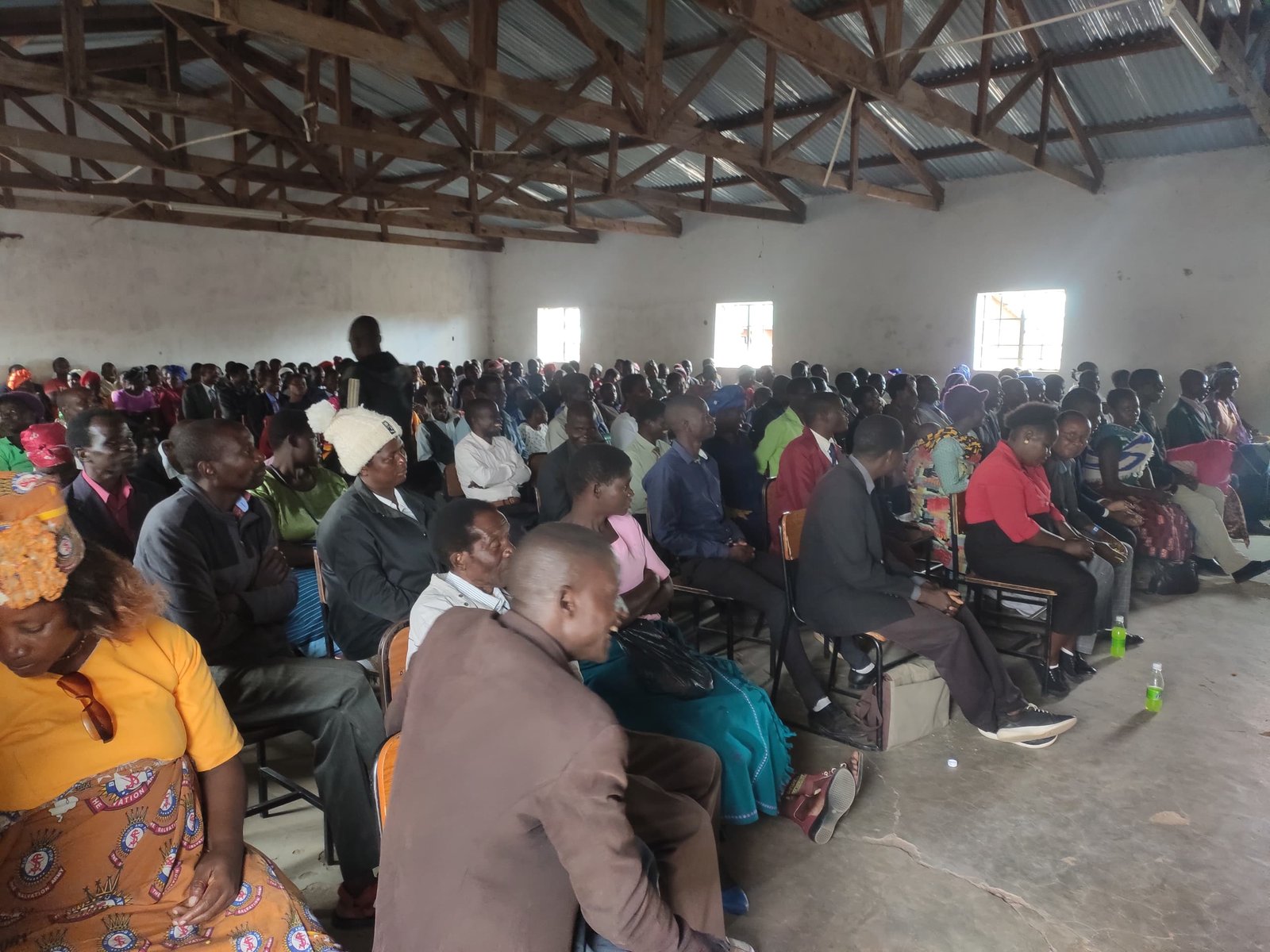 A second view across the seated congregation inside the hall.