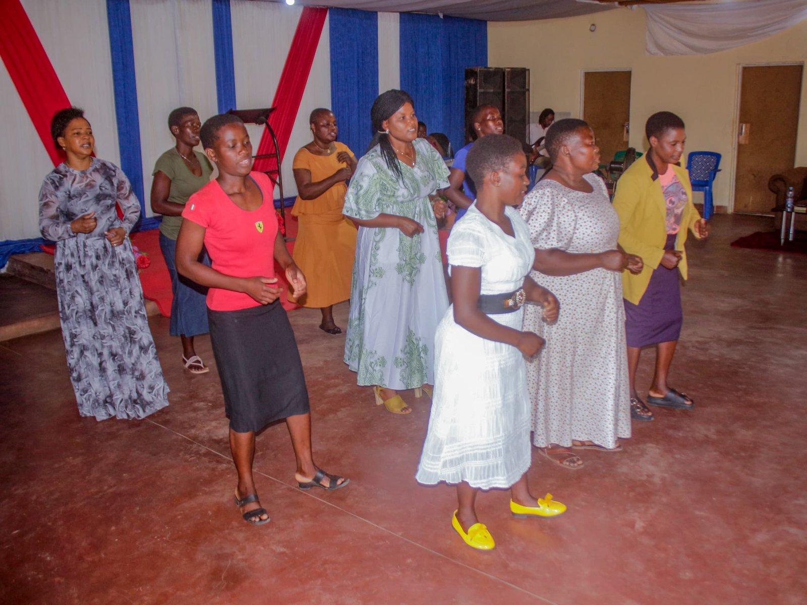 Women and young people stand together near the front of the hall.